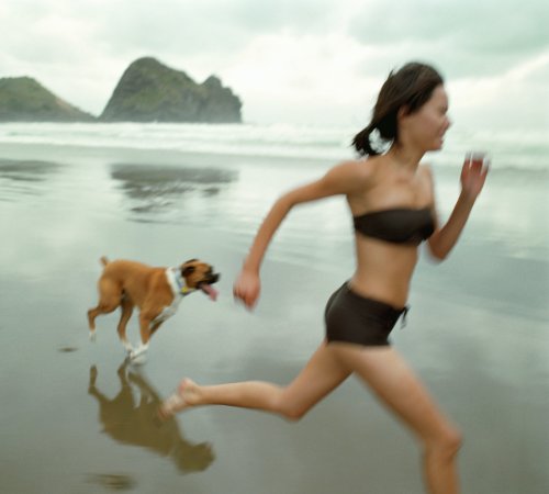 running with dog on wet beach